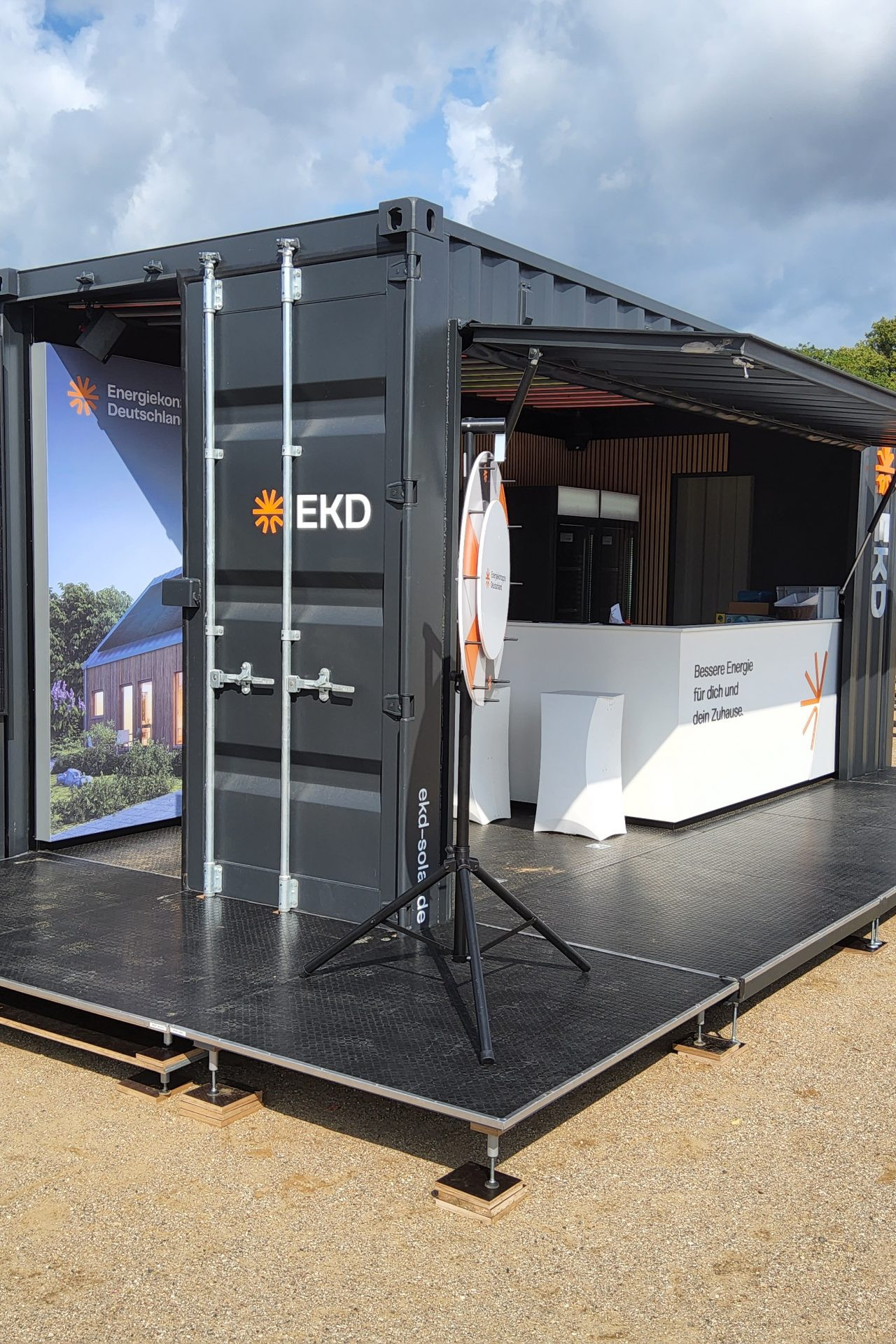 Der graue Container der EKD Roadshow mit Solarpanel und Infostand.